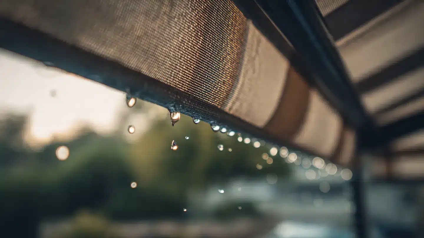 Close-up of water droplets on a retractable awning, showcasing the fabric texture and demonstrating its effectiveness in providing shade and protection from rain.